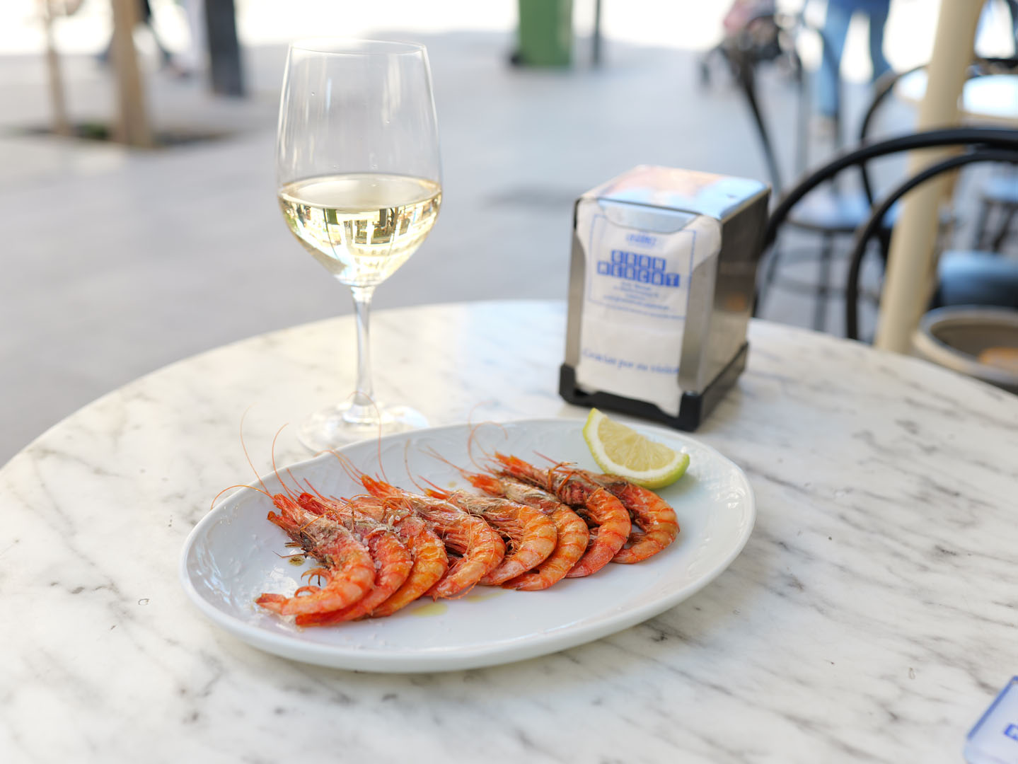 Plato de gambas a la plancha con copa de vino blanco