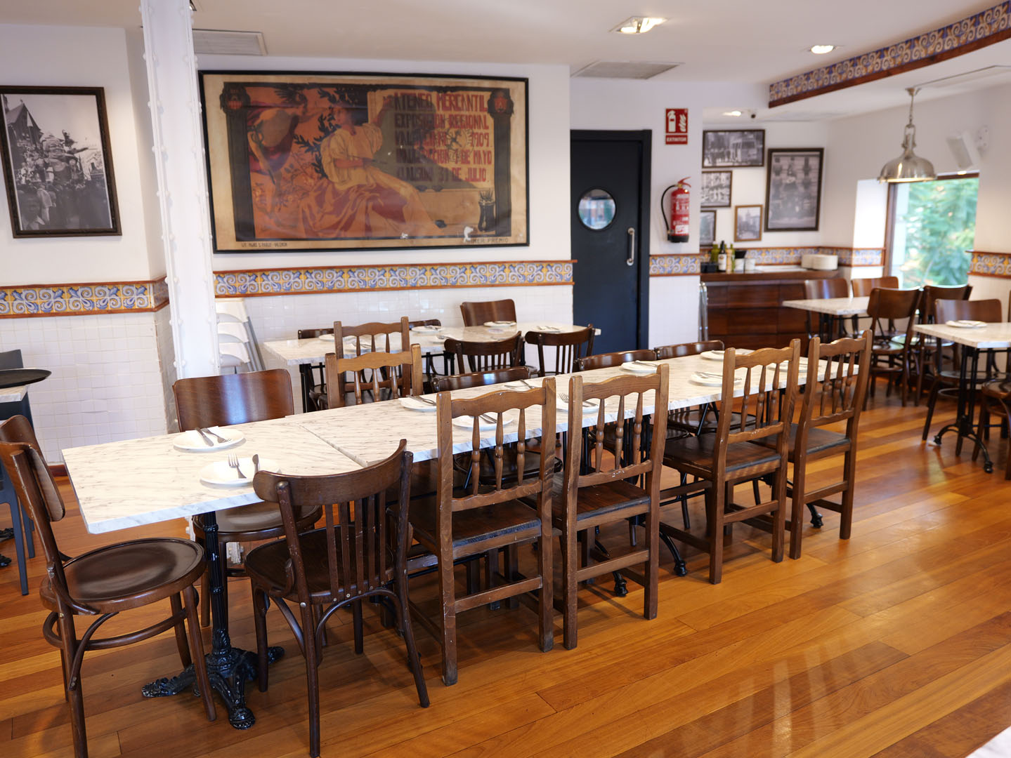 Comedor superior de Gran Mercat con mesas de mármol y sillas de madera